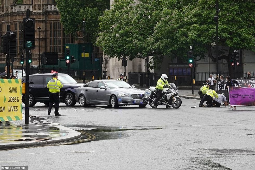 An activist from a group demonstrating outside Parliament's gates in Westminster today ran towards Boris Johnson's Jaguar