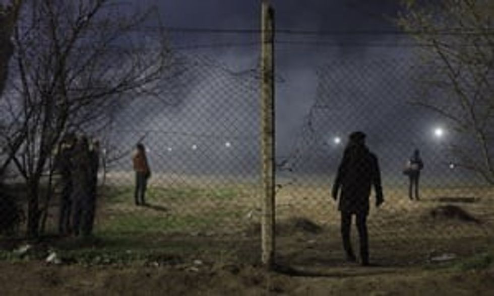 Asylum seekers waiting at the Pazarkule border crossing between Turkey and Greece, as Greek police fire ear gas canisters