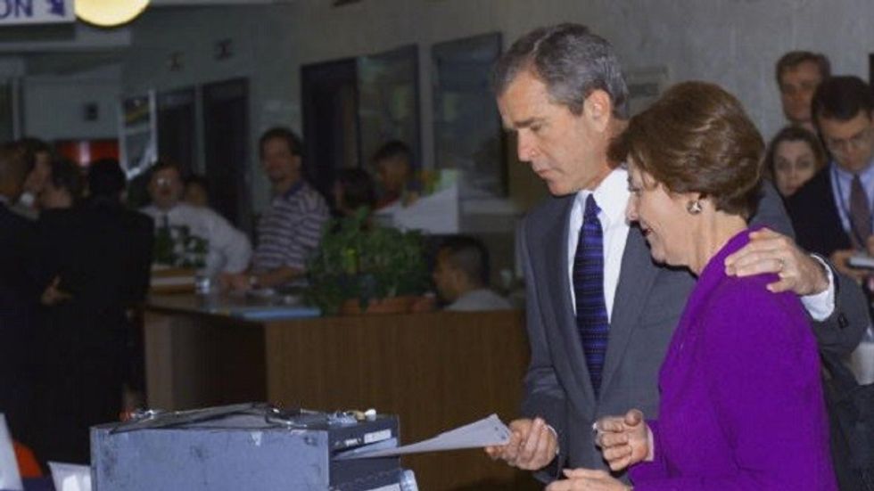 AUSTIN, UNITED STATES: Republican presidential hopeful and Texas Governor George W. Bush and his wife Laura drop their Texas primary ballot, which allows voting for one week prior to the 14 March, 2000 primary, into the ballot box early 08 March 2000 in Austin, Texas. Bush won the Super Tuesday votes over Republican challenger John McCain by a large margin. (ELECTRONIC IMAGE) AFP PHOTO/ Paul J. RICHARDS (Photo credit should read PAUL J. RICHARDS/AFP/Getty Images)