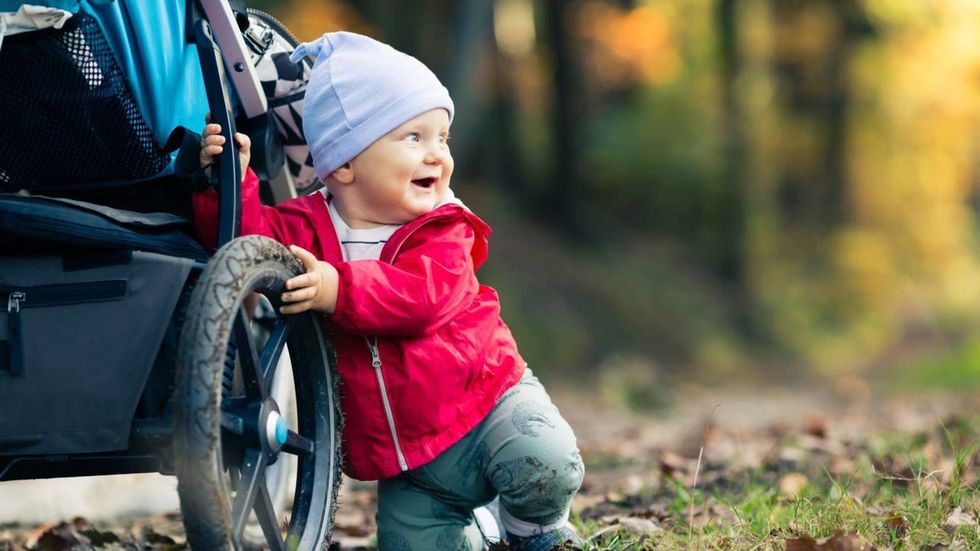baby smiling with stroller hiking family woods