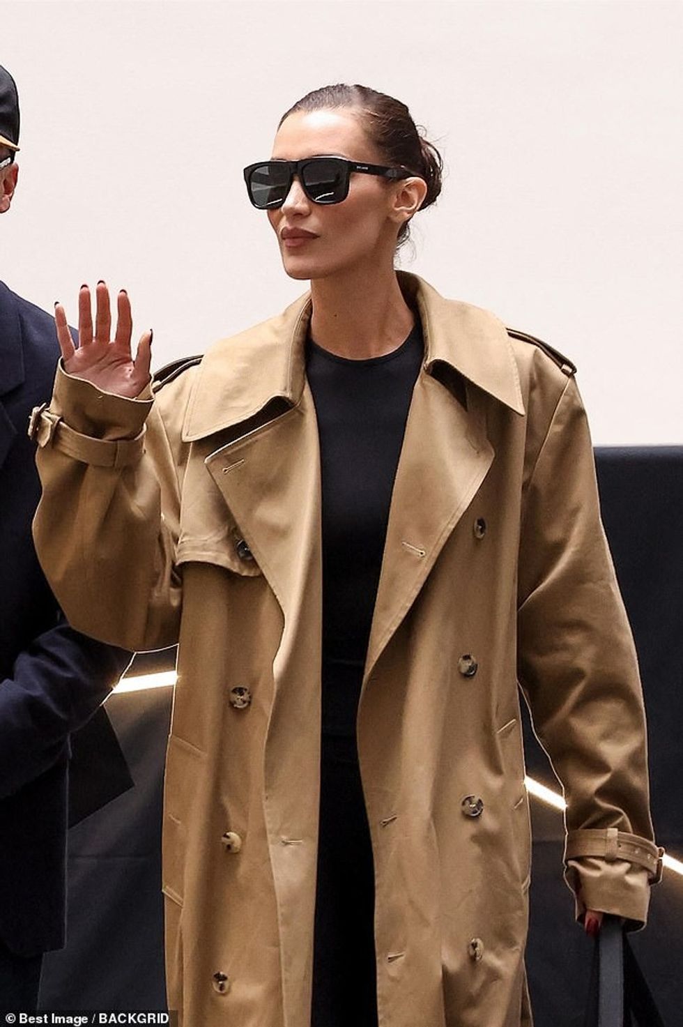 Bella Hadid, 27, cut a stylish figure in a brown trench coat as she touched down for the start of Paris Fashion Week on Sunday