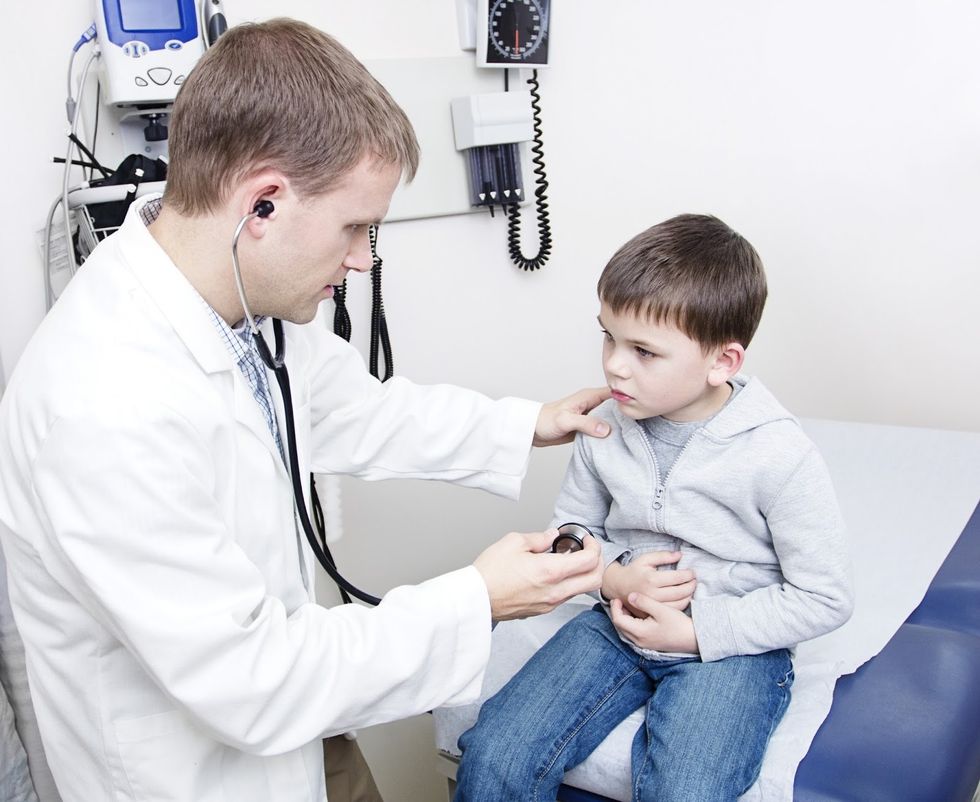 bigstock Doctor Examining sick little b 55406405
