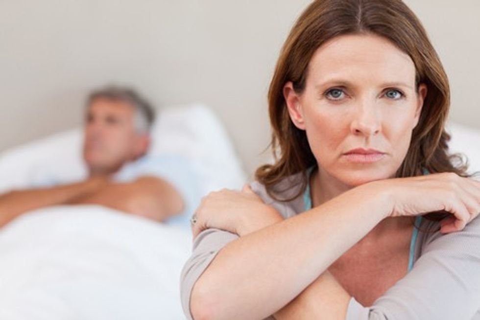 bigstock Sad woman on the bed with her 27565094