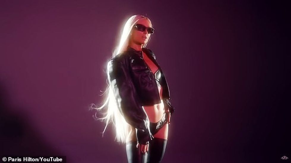 Biondja statuja mban zgjatime flokësh që i kanë flokët e gjatë duke i larë të pasmet kur fansat jashtë kamerës po i fryjnë drejt e pas saj.