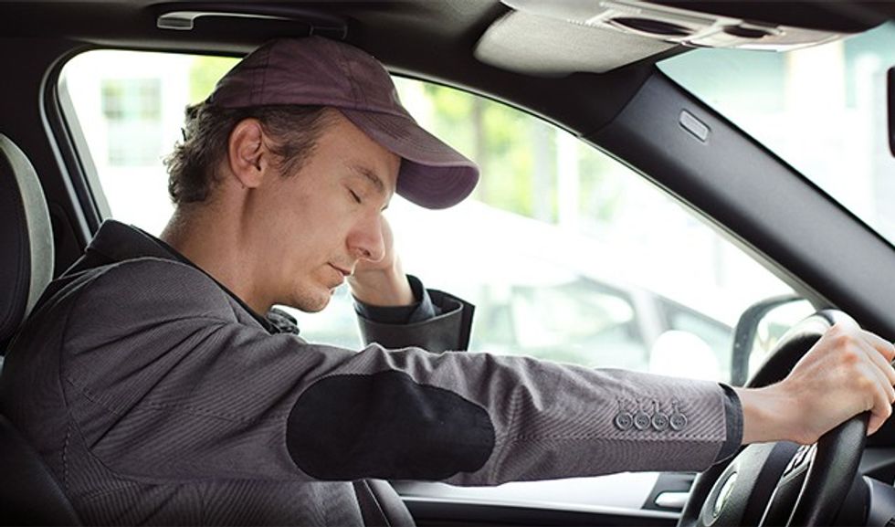 Bored, tired man sleeping at the wheel of his car