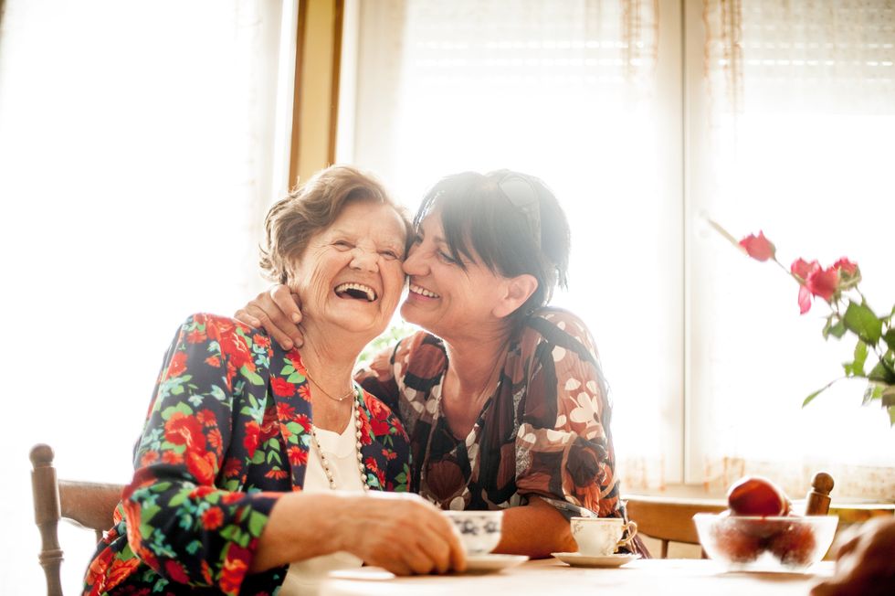 BTR Daughter hugging mother while having tea