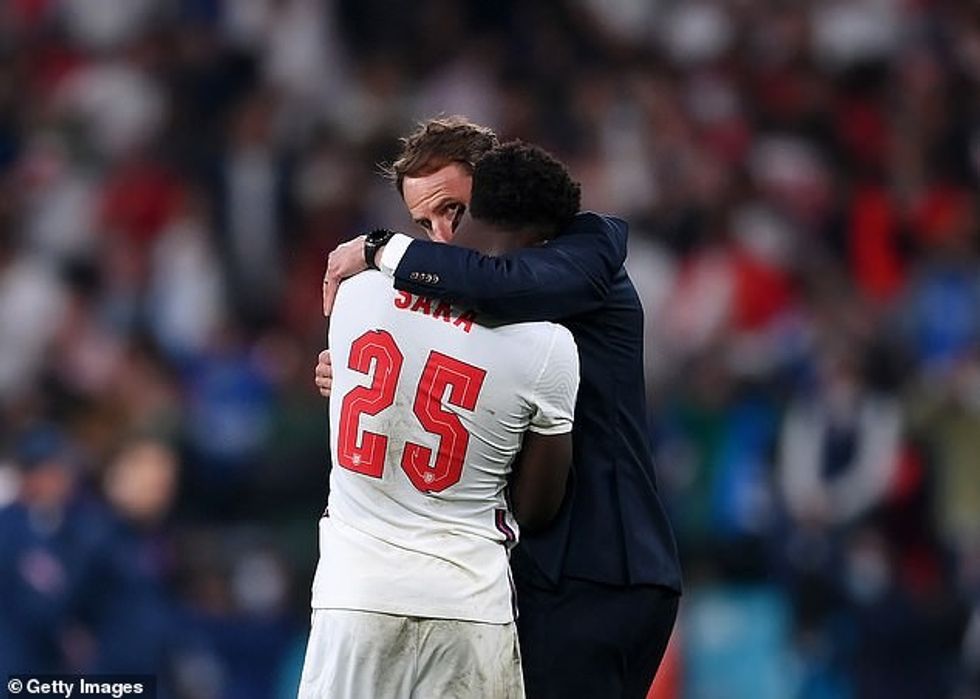 Bukayo Saka (përpara) përqafon Gareth Southgate (mbrapa) pasi humbi një penallti gjatë finales së Euro 2020. Ylli i Anglisë u dërgua më pas në internet pas ndeshjes
