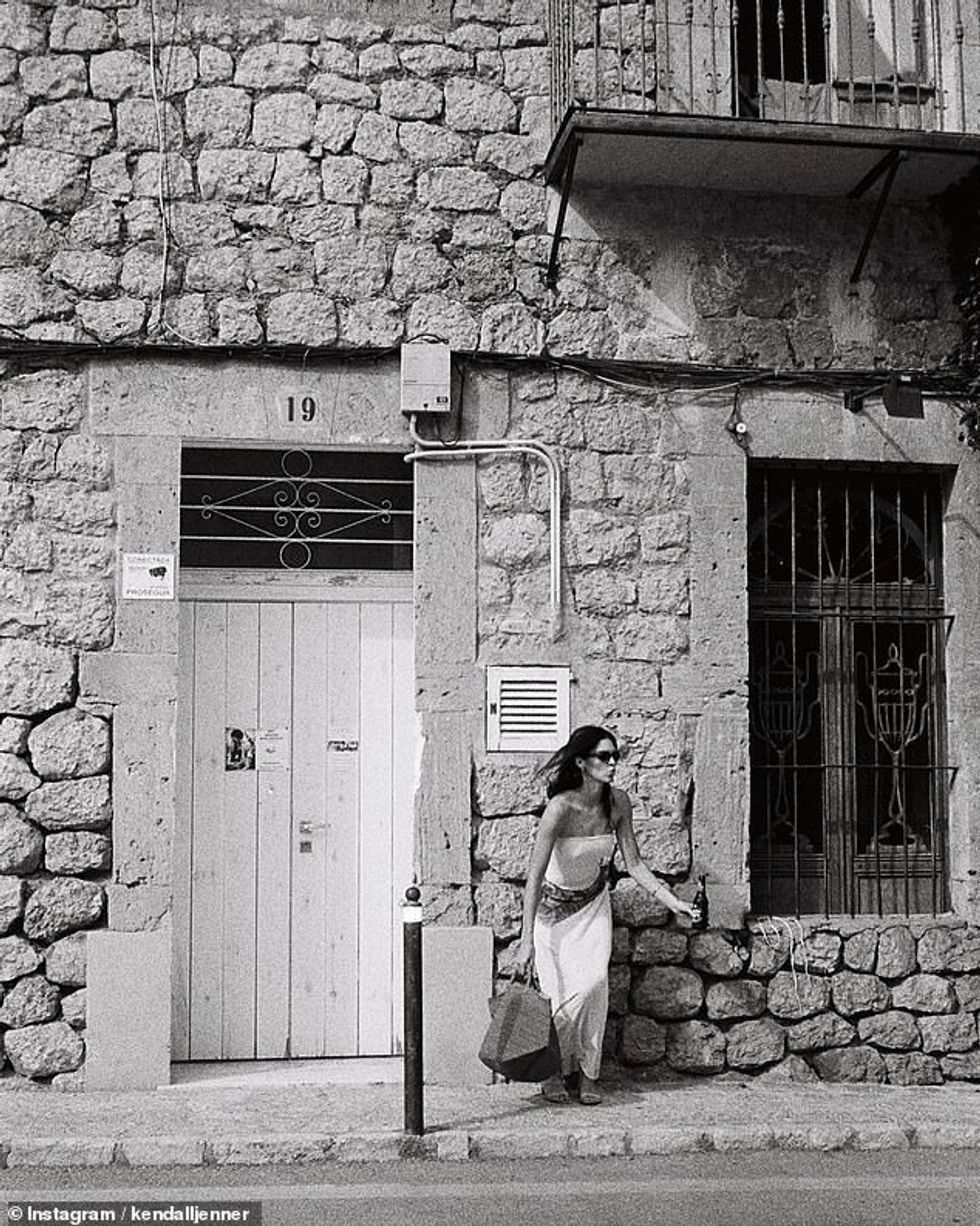 Bukuroshja brune postoi gjithashtu një foto të saj me një top tub të bardhë dhe fund maxi ombre - teksa pozonte pranë një ndërtese prej guri.