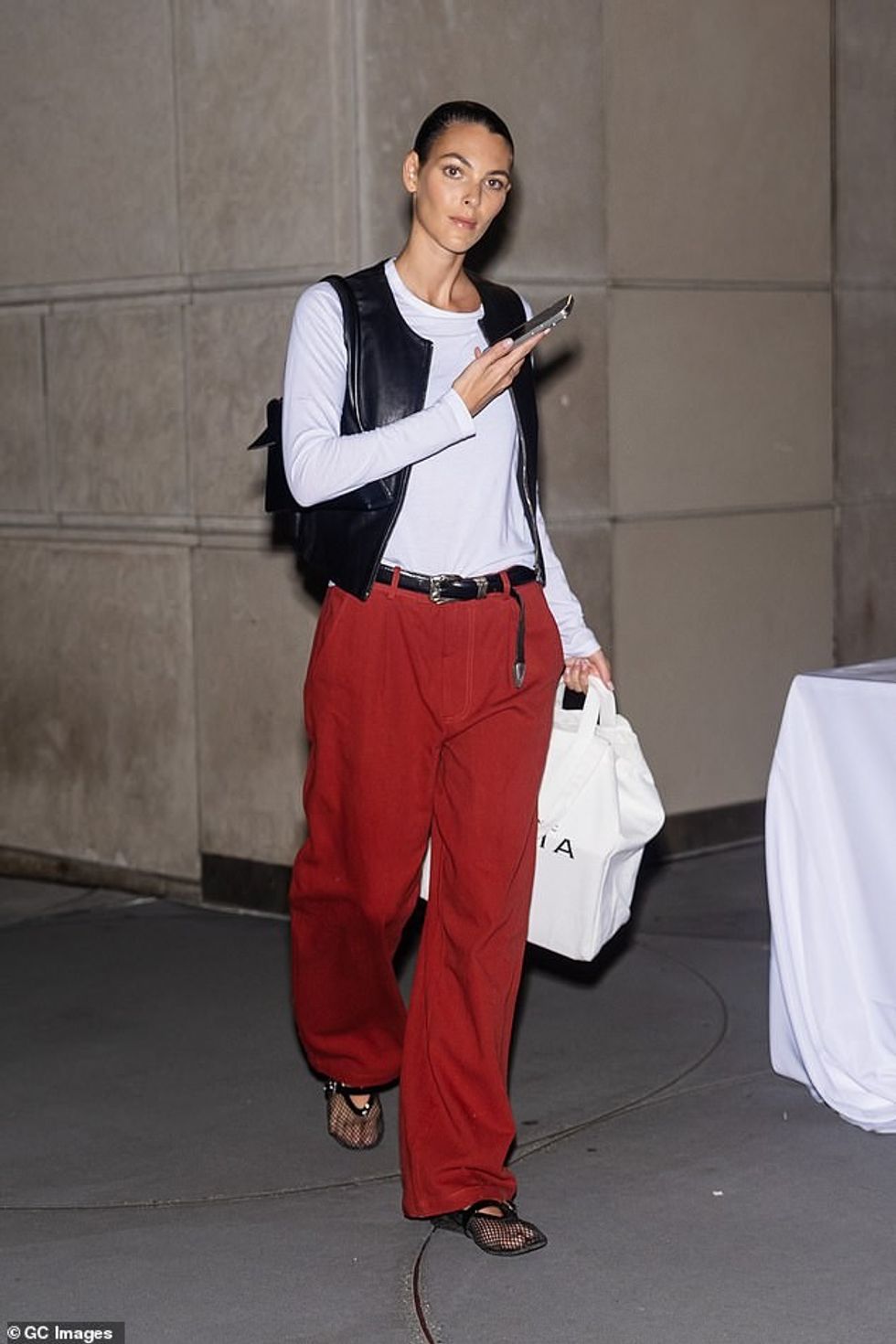 Bukuroshja italiane zgjodhi një pamje të qetë me një bluzë të bardhë, një jelek lëkure të zezë dhe pantallona të kuqe të ndezura.