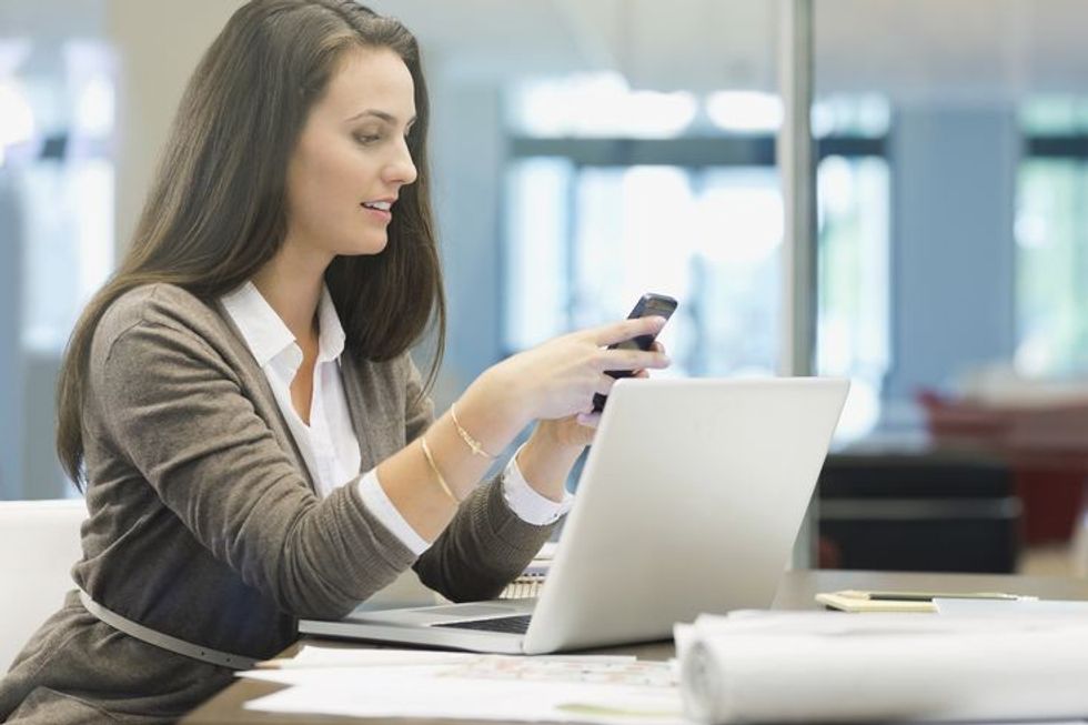 businesswoman using smart phone in office 463028331 5a519849845b3400374dce36