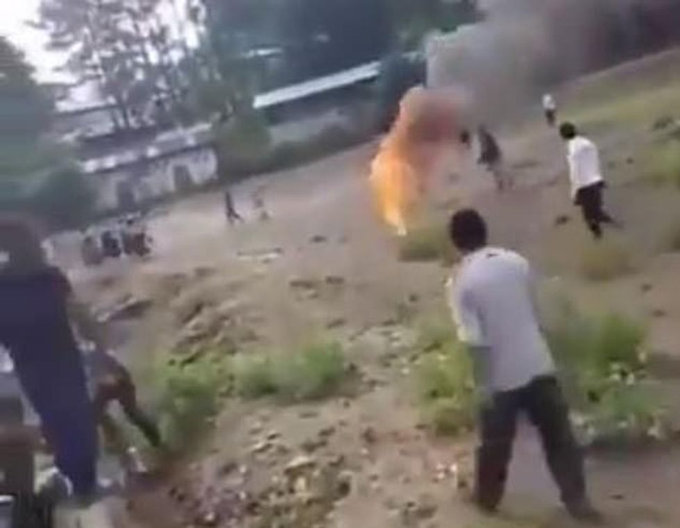 Bystanders looked from a distance as Domingo Choc (pictured on fire) screamed for help. Authorities are seeking arrest warrants for seven individuals