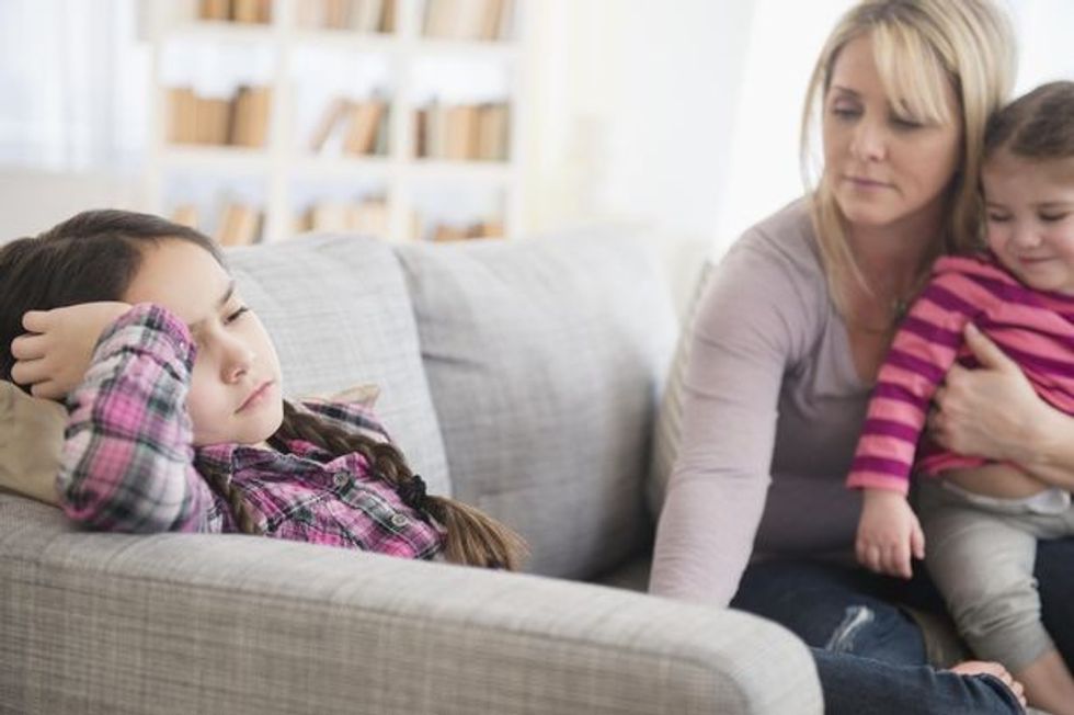 Caucasian mother comforting upset daughter on sofa