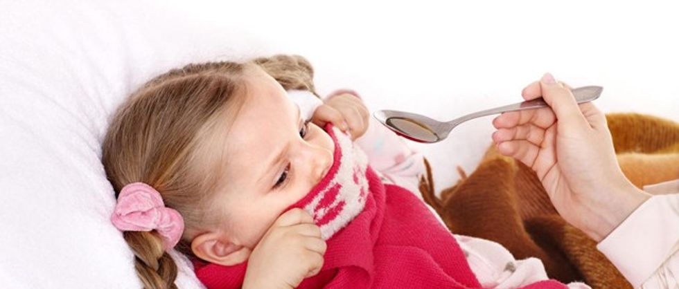 child coughs into elbow