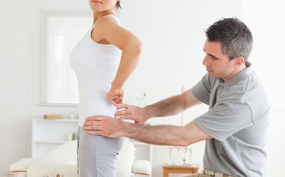 chiropractor examining a charming womans back