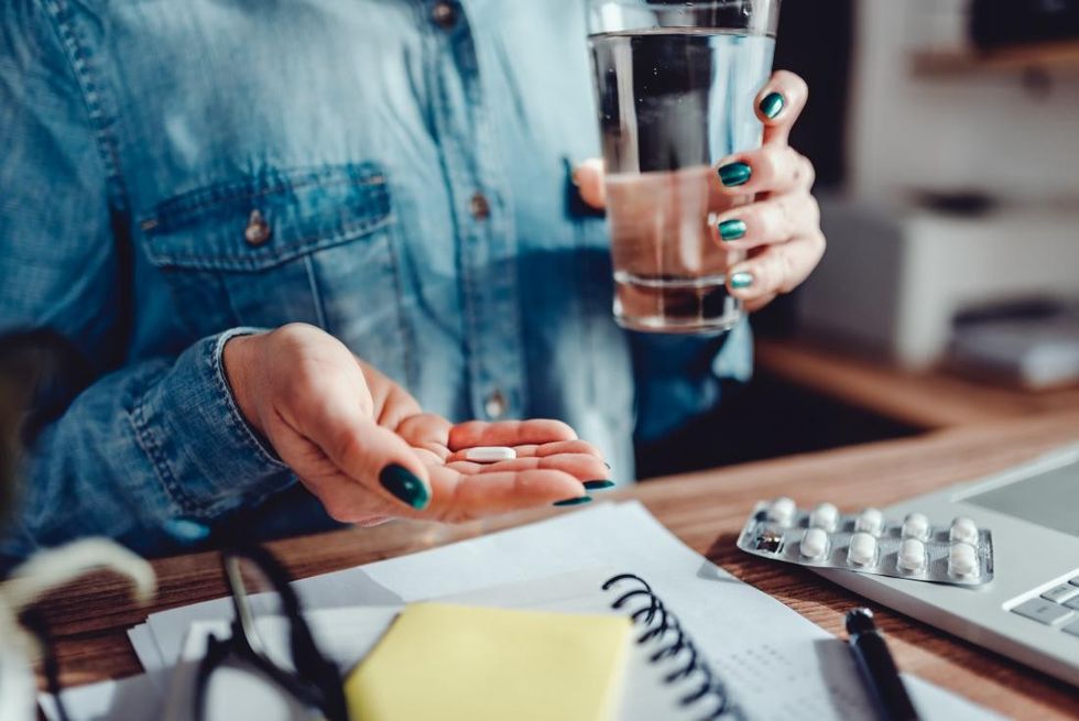 close up of woman s hands taking aspirin