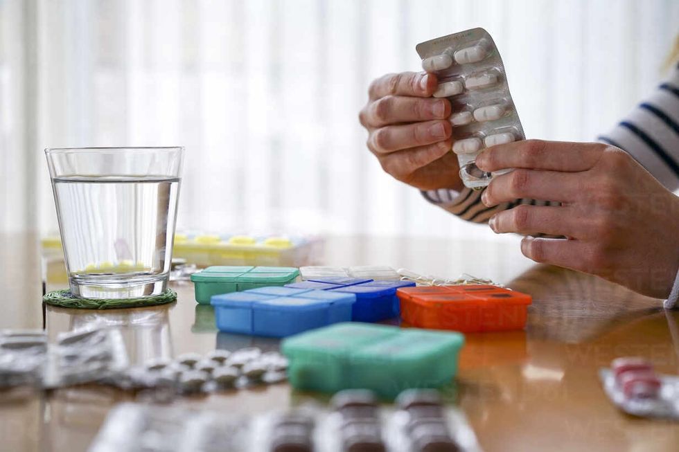 close up of woman taking medicine at home AFVF05823