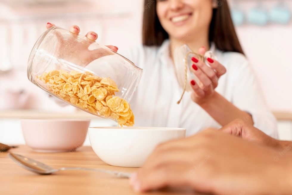 close up smiley girl pouring cereals bowl 23 2148334456