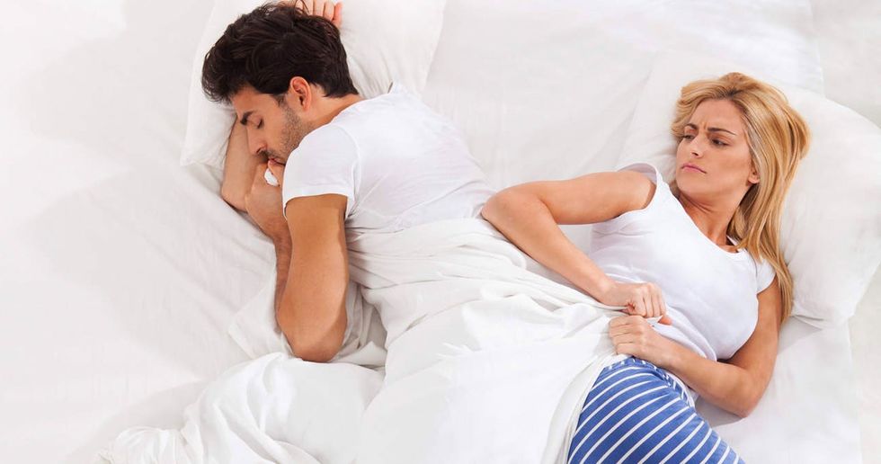 Couple In Bed With One Stealing Blanket