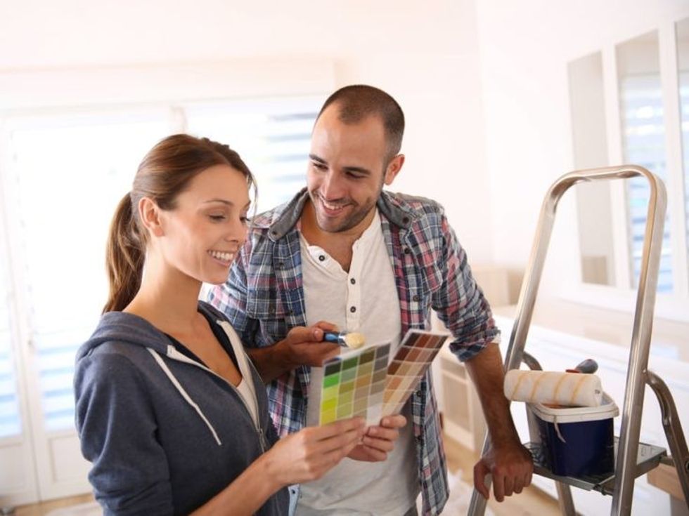 Couple in new house choosing color for walls e1560836985280