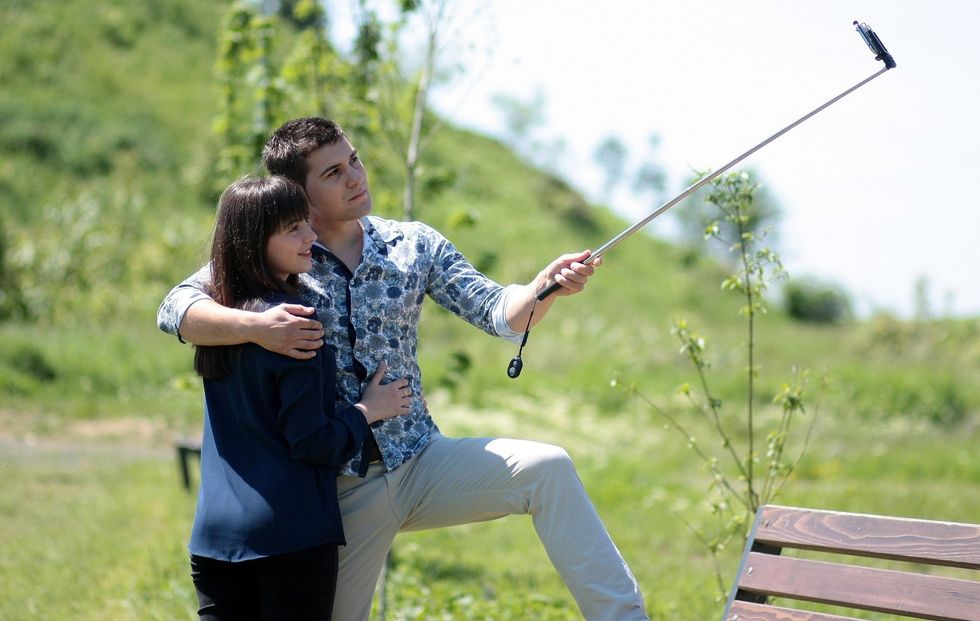Couple outdoors taking photo with selfie stick