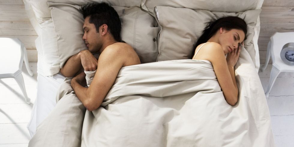 Couple Sleeping on Opposite Sides of Bed