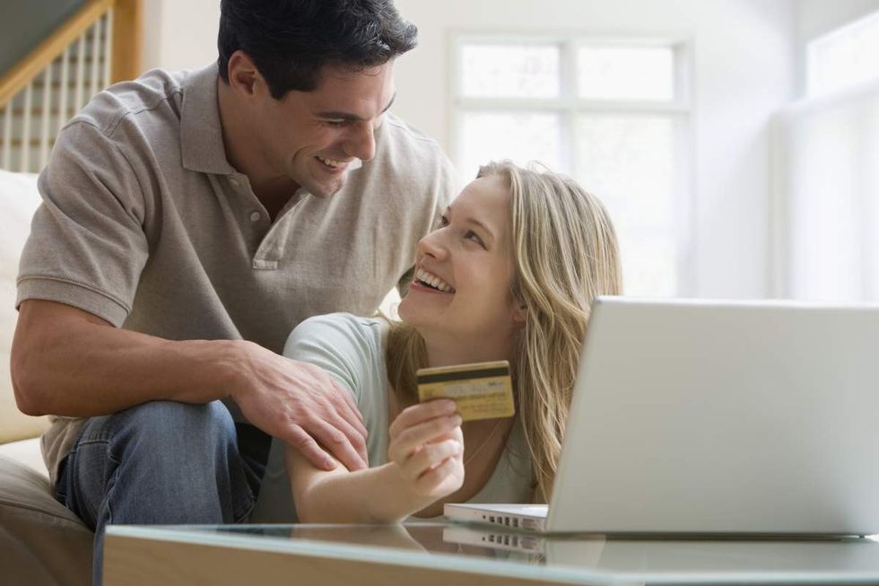 couple talking credit card laptop