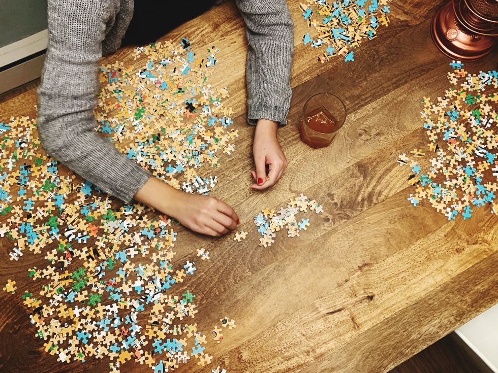cropped hands of woman playing jigsaw puzzle on royalty free image 1584042207 scaled