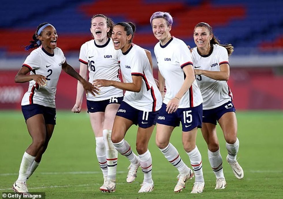 Crystal Dunn #2, Rose Lavelle #16, Christen Press #11, Megan Rapinoe #15 and Alex Morgan #13 of Team United States celebrate following their team's victory in the penalty shoot out after the Women's Quarter Final match between Netherlands and United States on day seven of the Tokyo 2020 Olympic Games at International Stadium Yokohama on July 30, 2021 in Yokohama, Kanagawa, Japan. The US Soccer Federation reached milestone agreements to pay its men's and women's teams equally, making the American national governing body the first in the sport to promise both sexes matching money