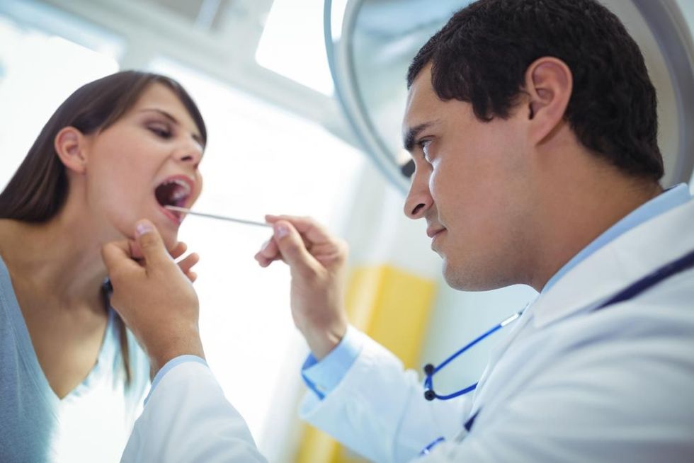 dentist looking at patient s tongue and mouth