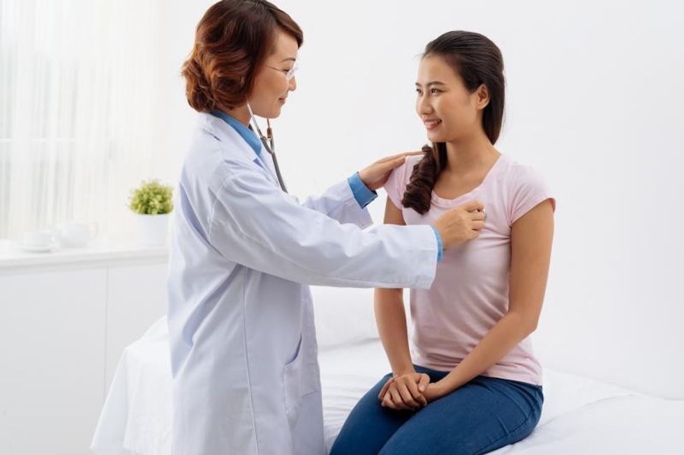 Doctor checking womans heart