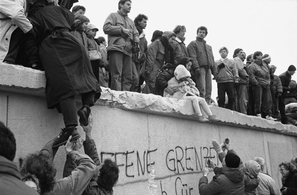 East Berliners climb onto the Berlin Wall to celebrate the effective end of the city's partition, 31st December 1989. (Photo by Steve Eason/Hulton Archive/Getty Images)