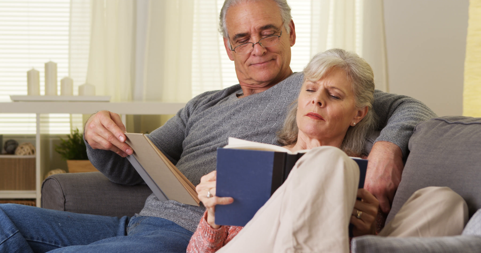 elderly couple sitting couch reading books e1inznugg F0000