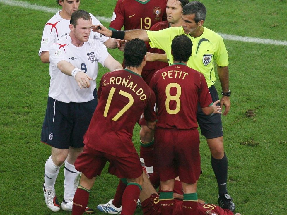 Englands Wayne Rooney pushes Portugals Cristiano Ronaldo as Portugals Ricardo Carvalho lies on th