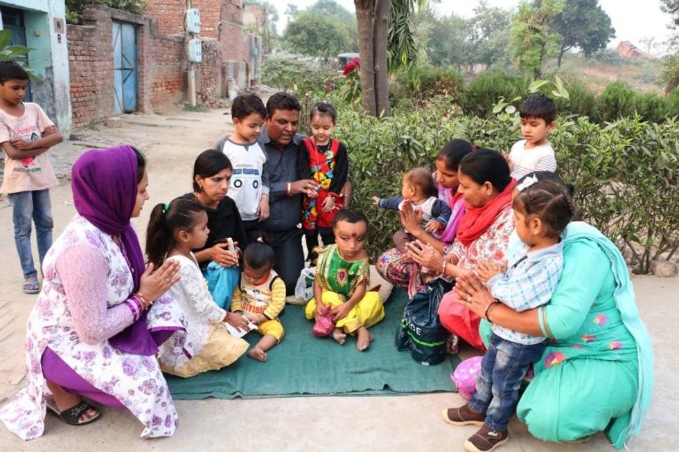 *** EXCLUSIVE - VIDEO AVAILABLE *** JALANDHAR, INDIA - OCTOBER 27: People sit around Pranshu to seek blessings from him on October 27, 2016 in Jalandhar, India. A SIX-YEAR-OLD Indian boy is worshiped by locals who believe he is the reincarnation of the Hindu god Ganesha. Pranshu, from Jalandhar in the Indian state of Punjab, was born with a mystery medical condition that has left him with a swollen forehead and deep set, narrow eyes. Although he is unable to walk, villagers believe Pranshu is a divine child and have nicknamed him 'Lord Ganeshaí - flocking to see him outside the nearby mosque. PHOTOGRAPH BY Ajay Verma / Barcroft Images London-T:+44 207 033 1031 E:hello@barcroftmedia.com - New York-T:+1 212 796 2458 E:hello@barcroftusa.com - New Delhi-T:+91 11 4053 2429 E:hello@barcroftindia.com www.barcroftimages.com