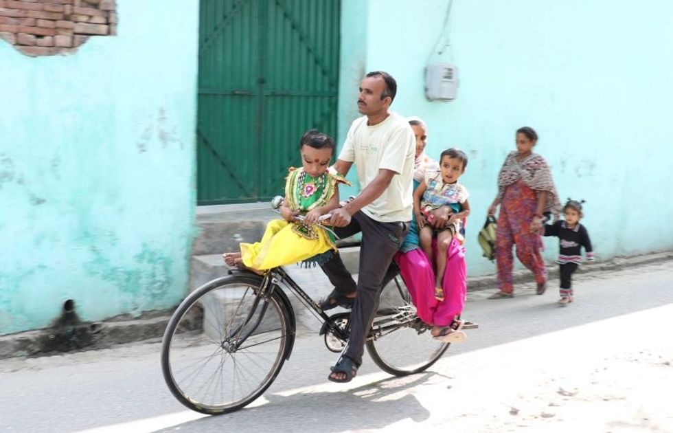 *** EXCLUSIVE - VIDEO AVAILABLE *** JALANDHAR, INDIA - OCTOBER 27: Pranshu travels on bycycle with his father to the mosque where people come to visit him on October 27, 2016 in Jalandhar, India. A SIX-YEAR-OLD Indian boy is worshiped by locals who believe he is the reincarnation of the Hindu god Ganesha. Pranshu, from Jalandhar in the Indian state of Punjab, was born with a mystery medical condition that has left him with a swollen forehead and deep set, narrow eyes. Although he is unable to walk, villagers believe Pranshu is a divine child and have nicknamed him 'Lord Ganeshaí - flocking to see him outside the nearby mosque. PHOTOGRAPH BY Ajay Verma / Barcroft Images London-T:+44 207 033 1031 E:hello@barcroftmedia.com - New York-T:+1 212 796 2458 E:hello@barcroftusa.com - New Delhi-T:+91 11 4053 2429 E:hello@barcroftindia.com www.barcroftimages.com
