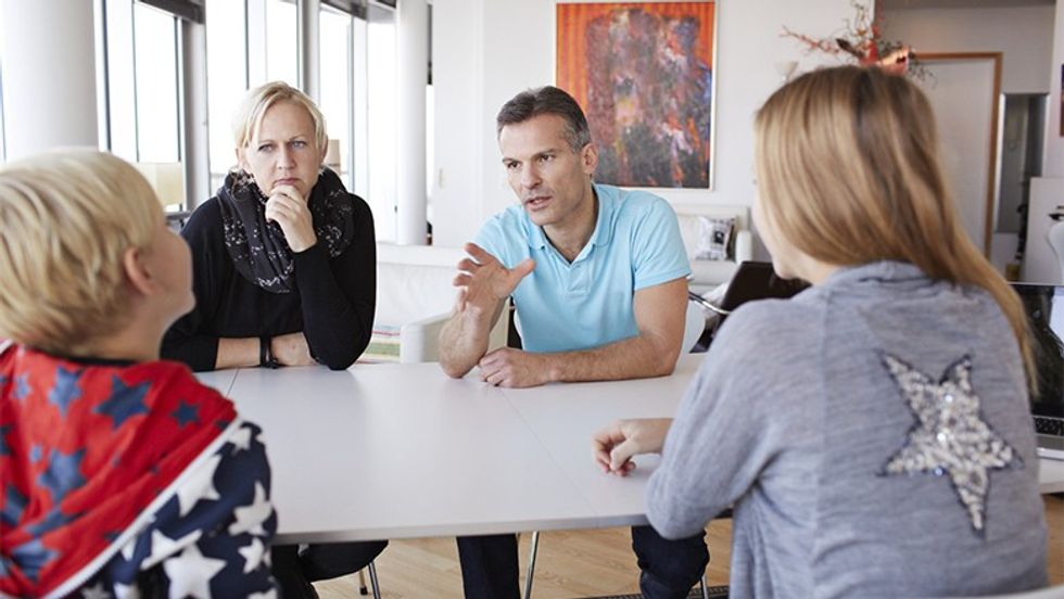 Family of 4 having a discussion at dinner table
