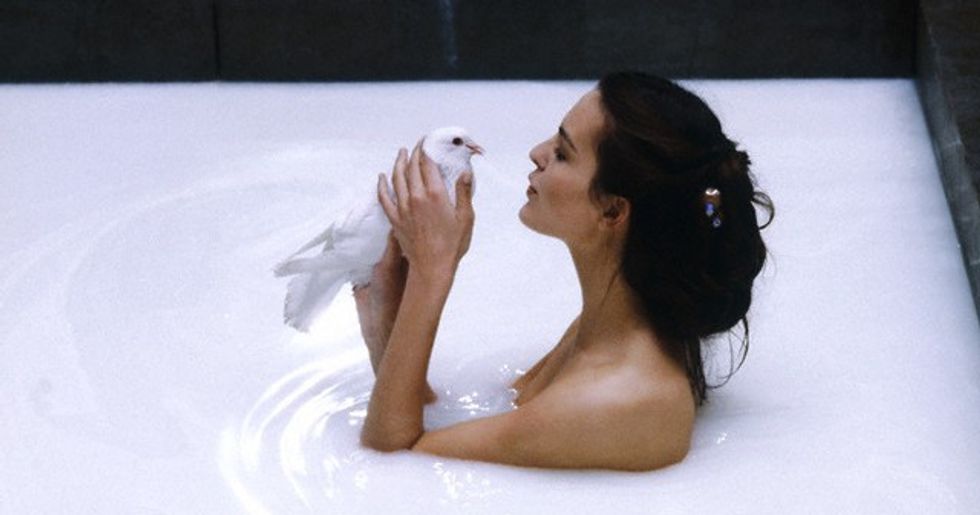 February 1984 --- The French actress Carole Bouquet holds a white bird and baths in milk, during the shooting of the movie Good King Dagobert. --- Image by © Fabian Cevallos/Sygma/Corbis