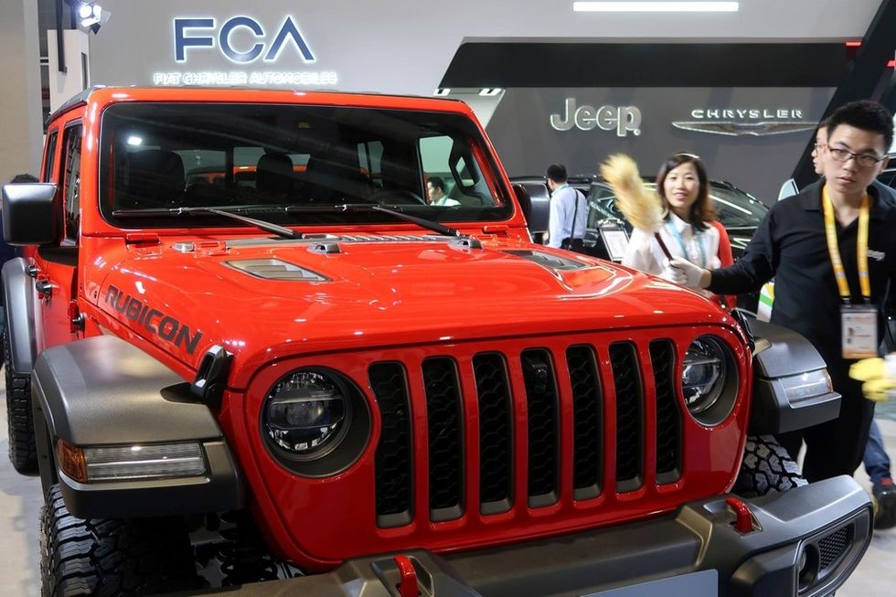 FILE PHOTO Staff member cleans a Jeep Gladiator pickup truck displayed at the Fiat Chrysler Automobiles FCA booth during the second China International Import Expo CIIE in Shanghai