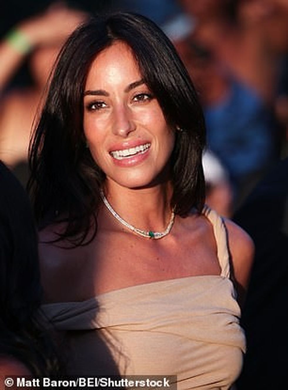 Flokët e saj brune ishin të ndara në mes dhe pa mundim rrodhën poshtë shpatullave të saj me valë elegante