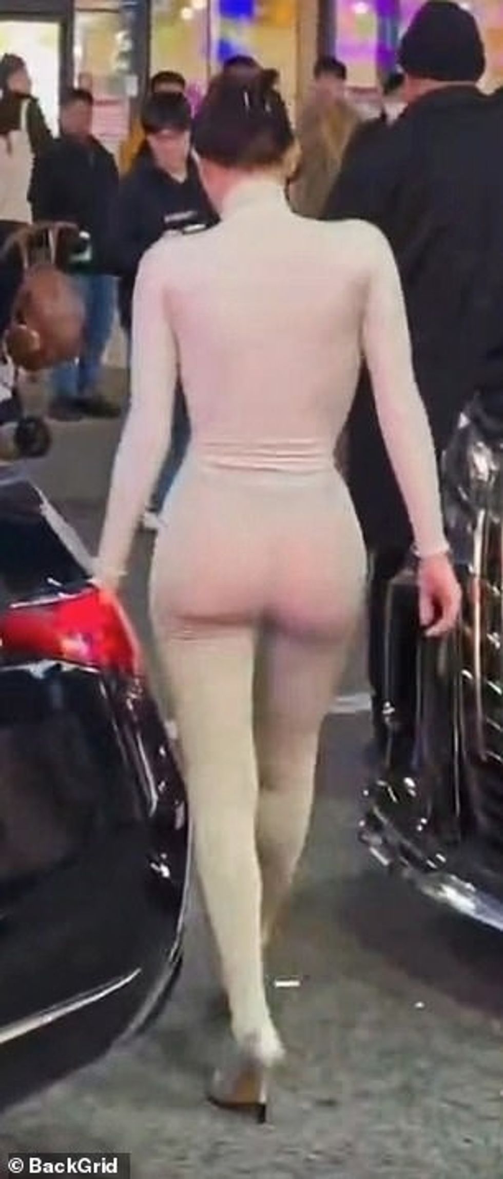 Flokët e saj të errët ishin tërhequr përsëri në një topuz të hijshëm dhe ajo mbante syze dielli të errëta