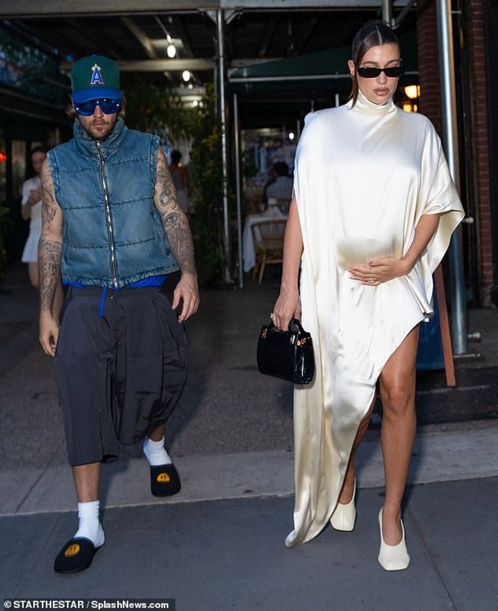 For her second outfit, Hailey donned an ivory, satin, asymmetric mini dress with one flared sleeve and a diagonally cut hemline