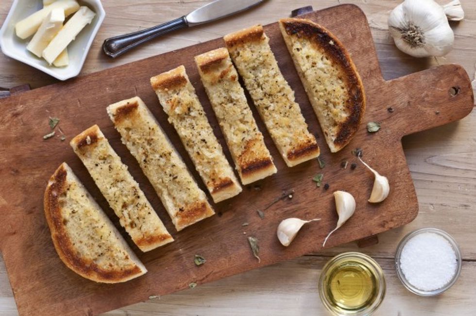 Garlic Bread Sliced on a Wooden Cutting Board; From Above; Ingredients for Garlic Bread