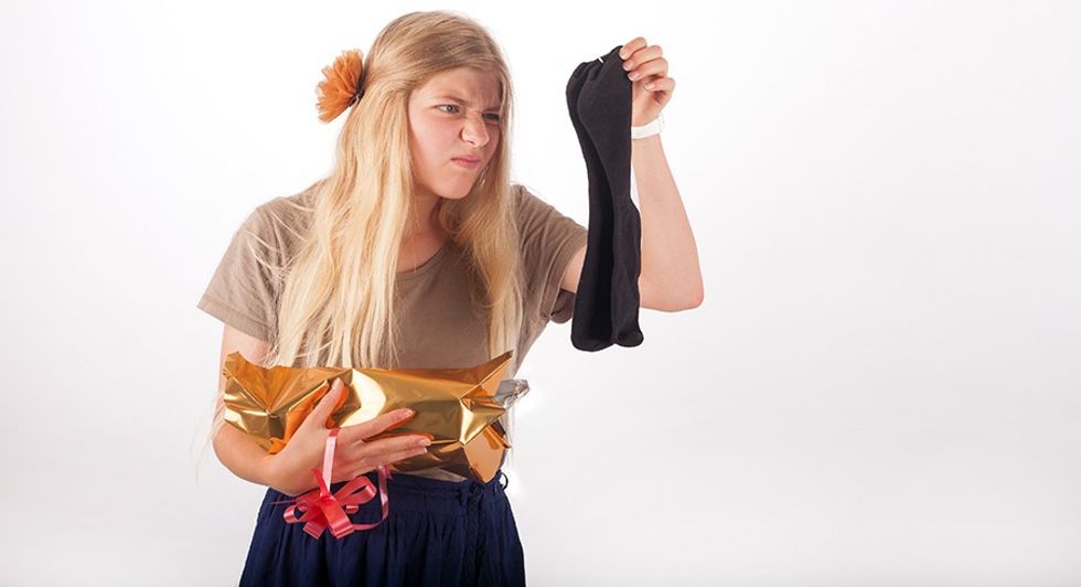 Girl not too happy with her gift which is a pair of socks