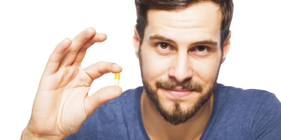 Handsome man showing pills