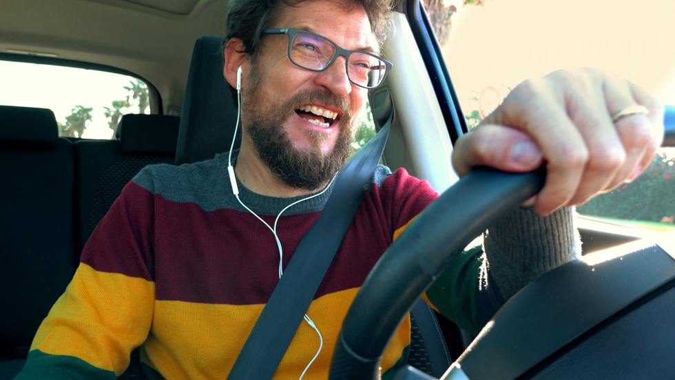 happy man in love driving car talking with girlfriend with earphone 4xjzk3gue F0011