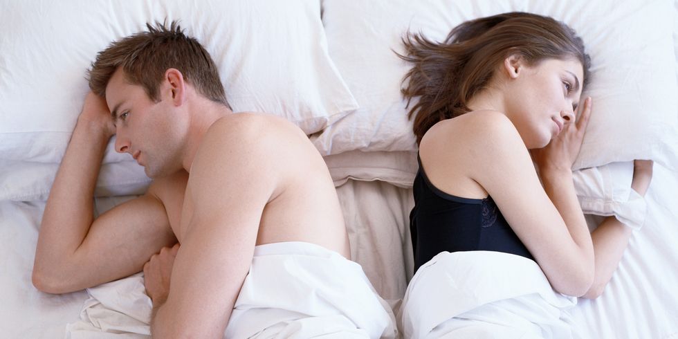 high angle view of a couple in bed lying back to back