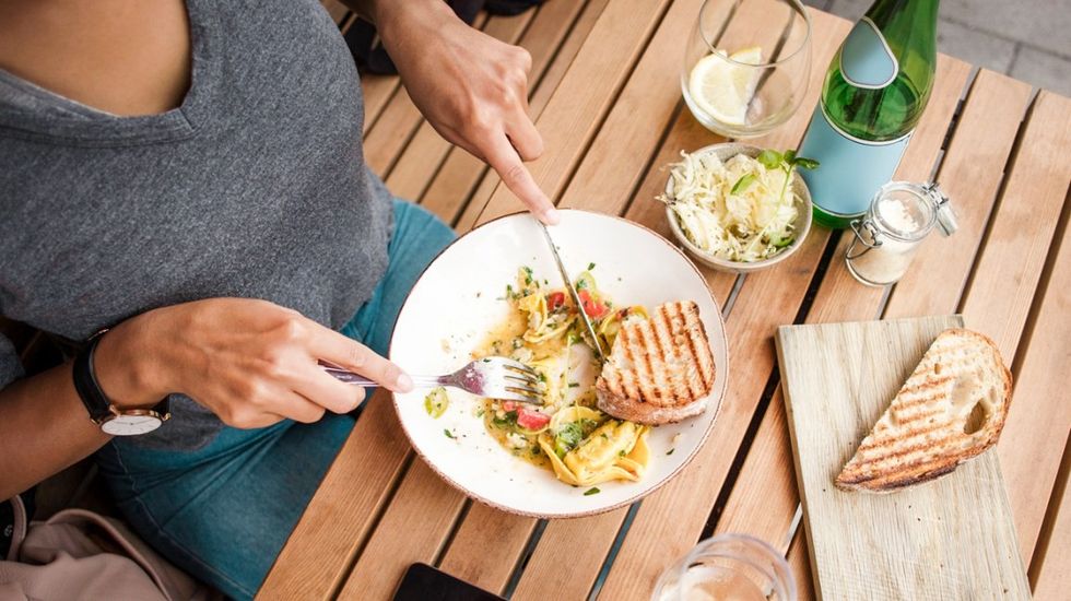 High angle view of woman having lunch at sidewalk cafe table header