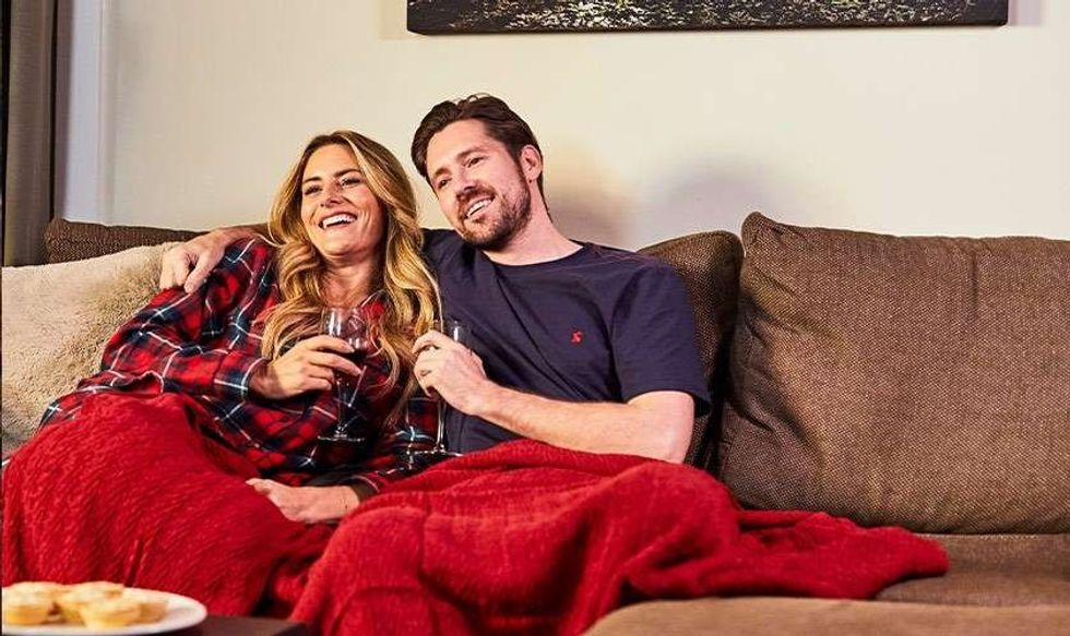 image.couple cuddling on the sofa watching tv..1689780195738