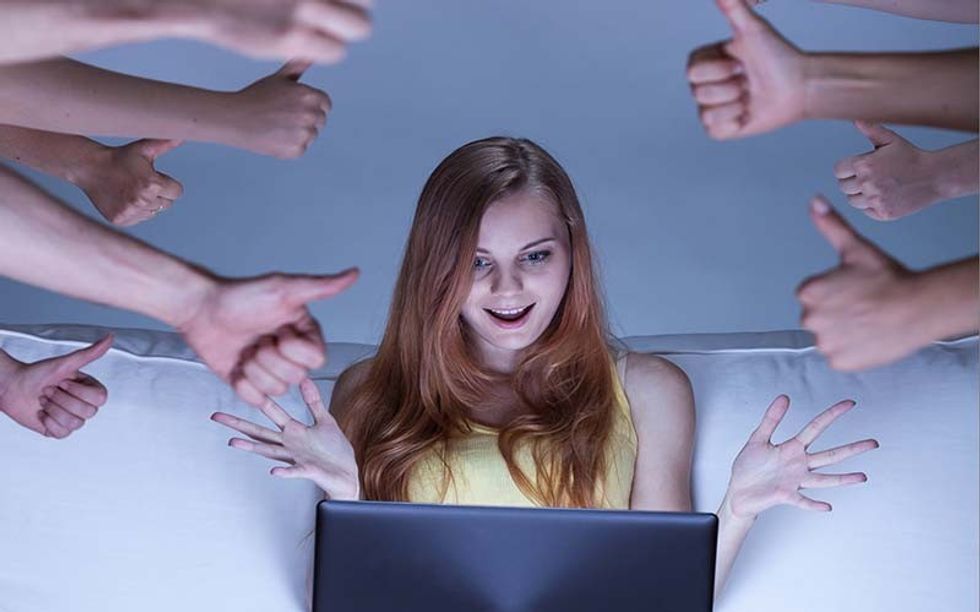 Image of excited facebook girl sitting on couch