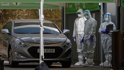 2020/03/25656134-8085957-Three_health_workers_in_protective_suits_wait_to_check_a_motoris-a-68_1583586475697.jpg